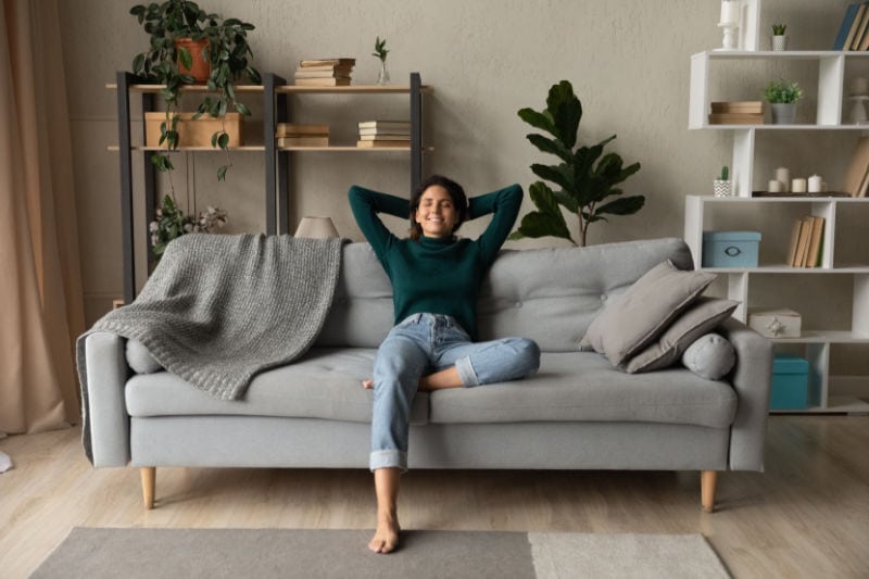 How a Whole-House Humidifier Keeps You Healthy. Woman sitting comfortably in her home.|Image of a humidifier. How a whole-house humidifier keeps you healthy.