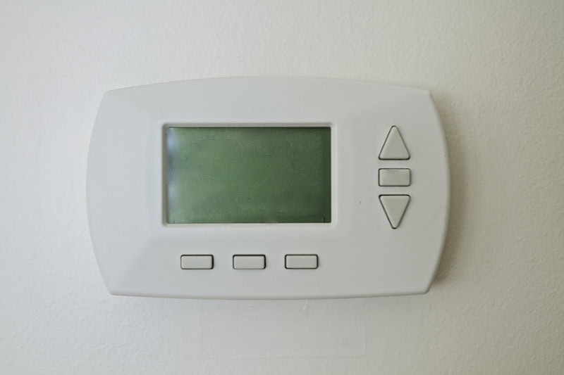 Why Is My Thermostat Blank? Photo of a digital thermostat mounted on the wall with a blank screen.