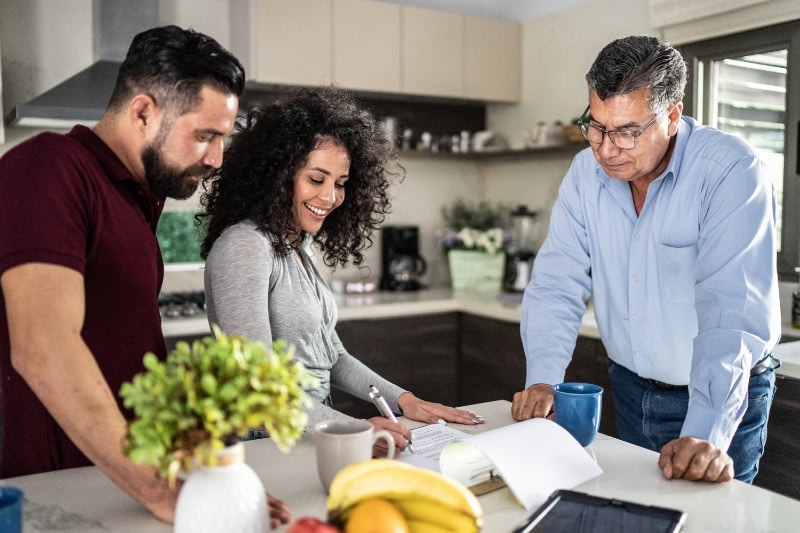 Think HVAC During Your Home Remodeling. Mid adult couple filling document in the kitchen at home.